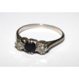 A three stone sapphire and diamond ring, set in white coloured metal. Size R