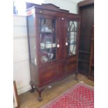 A 1930s mahogany display cabinet, the raised back over a pair of glazed doors and panelled centre