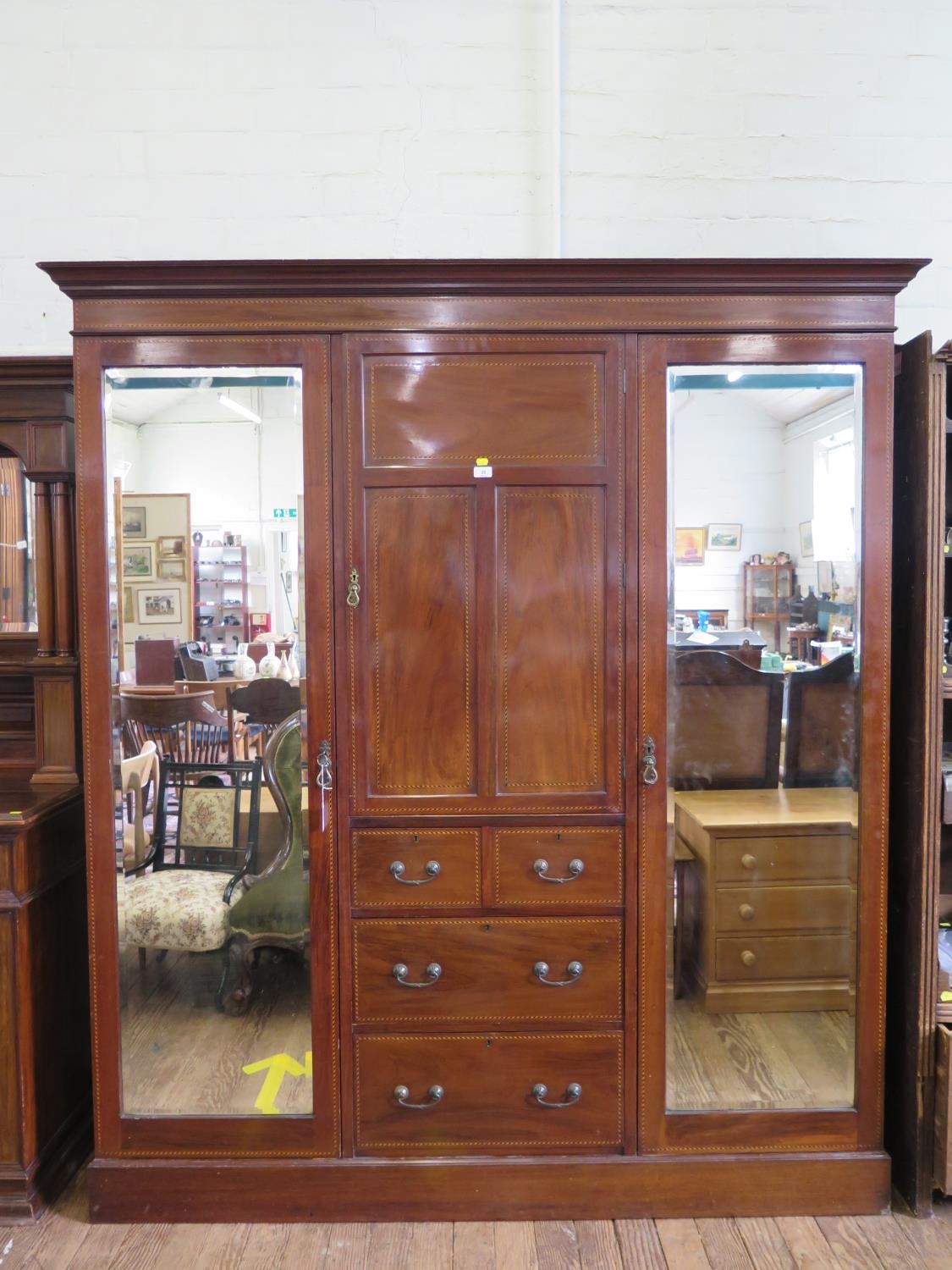 An Edwardian chevron banded mahogany compactum wardrobe, the central panelled door enclosing a shelf