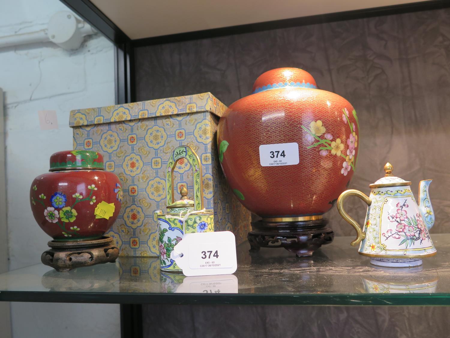 Two Cloisonné ginger jars and covers, both with floral branches on a red ground, largest 17 cm high,