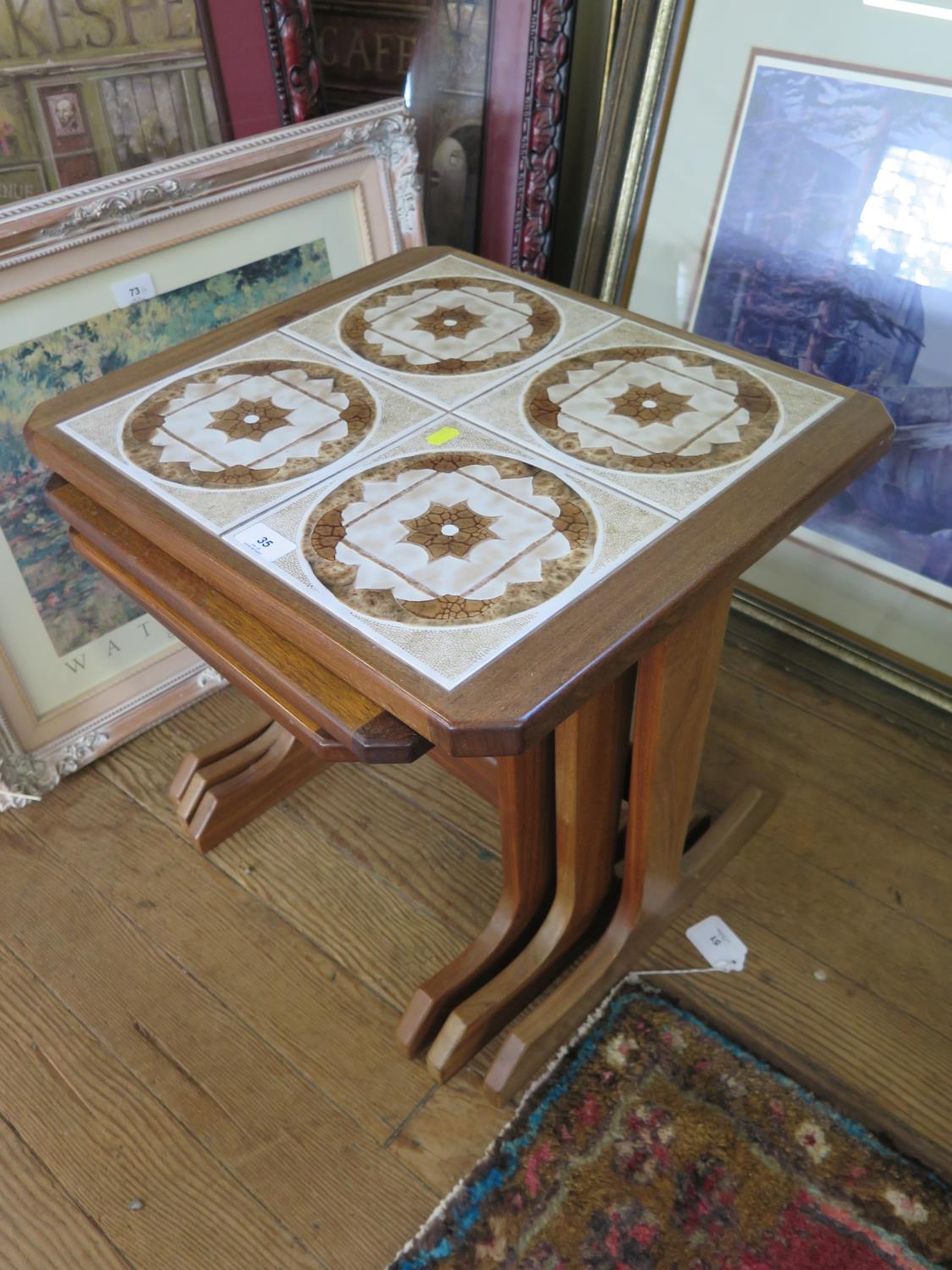 A G-Plan teak nest of three tables, the largest with tiled top, 49 cm wide