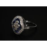 A Platinum sapphire and diamond ring. 4 central diamonds surrounded by calibre cut sapphires. The