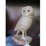 A carved wooden model of an owl standing with a dead mouse both set with glass eyes