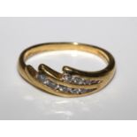 An 18 carat yellow gold ring set with ten round diamonds. Size H