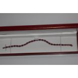 18ct white gold oval treated ruby and diamond line bracelet. Ruby 12.23ct. Diamonds 0.55ct. Boxed