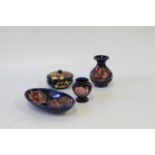 Moorcroft dark blue ground oval dish, 23cm, circular bowl and cover, 12cm, and two vases (4)