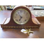 A 1920's oak cased mantel clock with brass winder