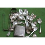 A collection of silver to include a cigarette case, sugar tongs, a napkin ring and spoons