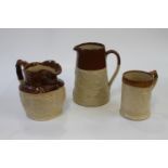 Two brown and beige stoneware jugs and a tankard, 16 to 24cm (3)