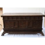 An Italian Oak Coffer. Possibly 16th century. The façade carved with panels of flowering foliage