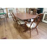 An Ercol Mahogany Dining Table and Six Chairs. With makers labels.