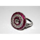 Platinum ruby and diamond dress ring set with a central old-cut diamond, a halo of rubies, a halo of