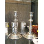 A pair of silver candle sticks. 18cm high