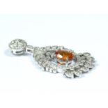 An 18 carat white gold diamond set pendant with a central articulated drop set with a fire opal