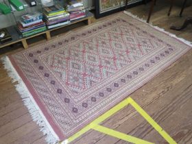 A Bokara style rug with geometric motifs on a dark pink ground, within a multiple border, 206cm x