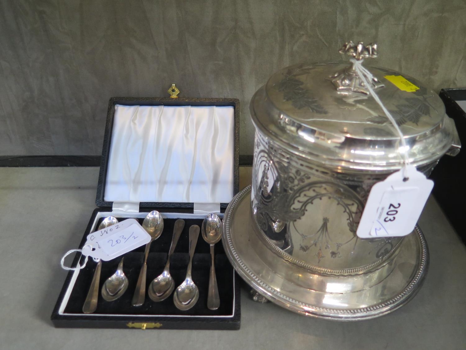 A silver plated biscuit barrel and a cased set of six spoons