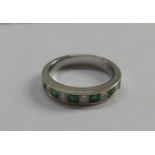 A white gold ring set with emeralds and diamonds, both gems cut square, size M