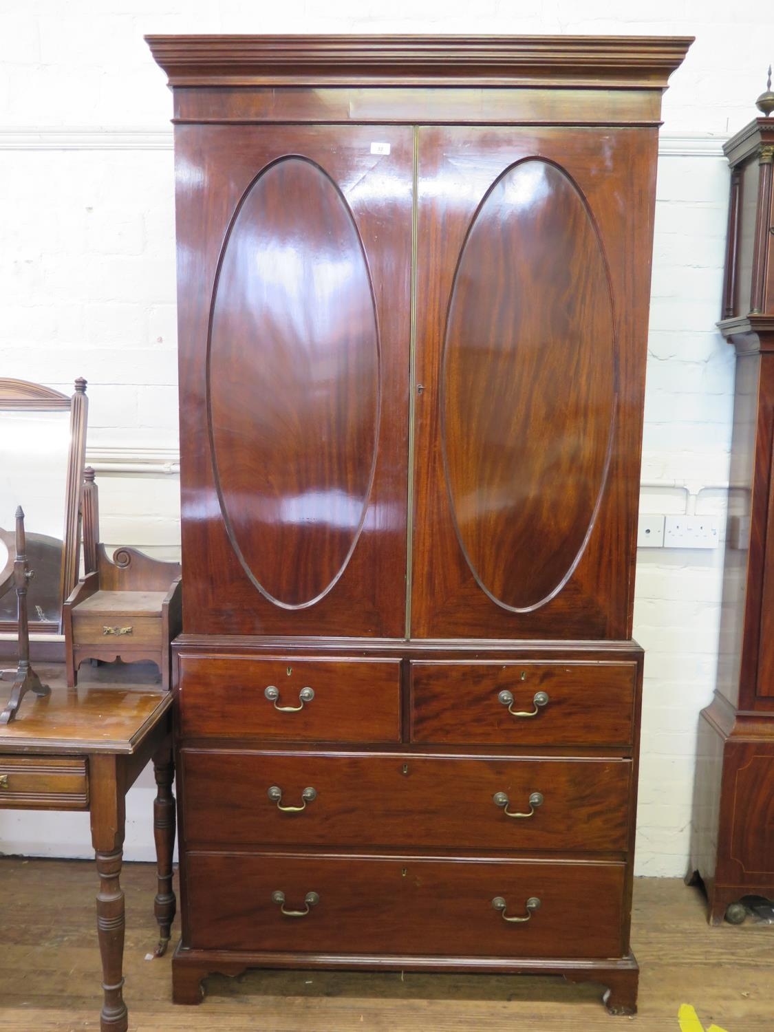 A Fine Hepplewhite Style Hanging Closet. Circa 1770. With stepped cornice above a pair of panel