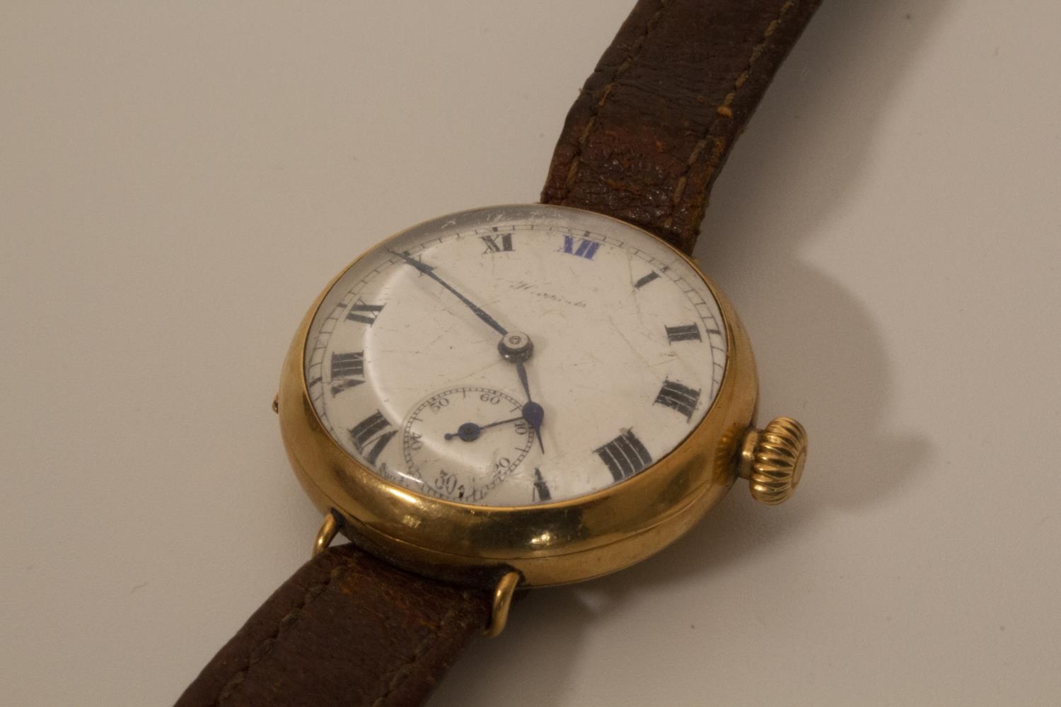 A lady's wrist watch gold colour with enamel dial and Arabic numerals