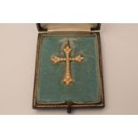 A gold cross set with seed pearls in original box