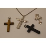 A silver cross pendant with three further cross pendants