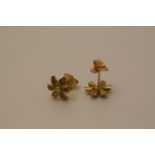 A pair of 18 carat gold earrings in the form of flower heads with diamond centres