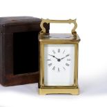 AN EARLY 20TH CENTURY BRASS CARRIAGE CLOCK OR TIMEPIECE the enamel dial with roman numerals, the