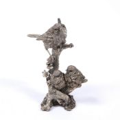 A CONTEMPORARY SILVER COVERED SCULPTURE depicting a robin and two of its young perched on a