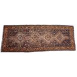 A MIDDLE EASTERN RED AND ORANGE GROUND RUG with a banded border and geometric decoration, 101cm x