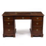 A GEORGIAN STYLE MAHOGANY PEDESTAL DESK the top with gilt tooled Morocco leather inset above one