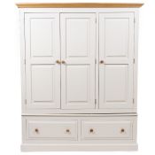 A MODERN CREAM PAINTED WARDROBE with three panelled doors above two long drawers with turned handles