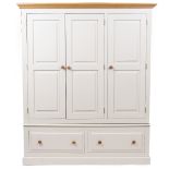 A MODERN CREAM PAINTED WARDROBE with three panelled doors above two long drawers with turned handles