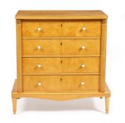 A CONTINENTAL SATIN BIRCH CHEST OF FOUR DRAWERS with faux ivory knob handles and raised on turned
