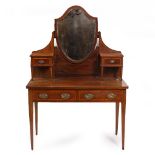 AN EDWARDIAN MAHOGANY DRESSING TABLE with shield shaped mirror, two frieze drawers and standing on