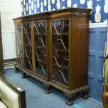 A MAHOGANY BREAKFRONT BOOKCASE CABINET with four astragal glazed doors, raised on claw and ball feet