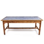 AN ANTIQUE PINE RECTANGULAR TABLE with tile inset top and square supports united by a stretcher,