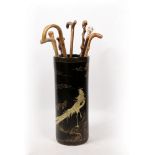 AN ORIENTAL EBONISED CYLINDRICAL STICK STAND together with a group of eight various walking