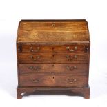 A GEORGE III MAHOGANY BUREAU with a fall front opening to reveal drawers and pigeon holes with a