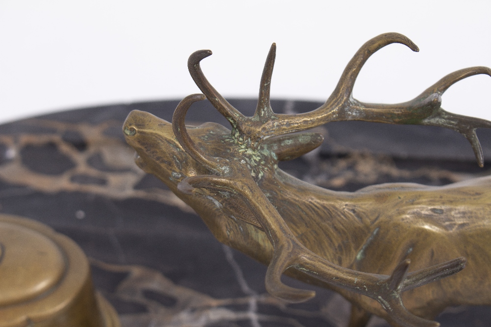 A LATE 19TH / EARLY 20TH CENTURY BRASS STAG AND INKWELL DESK STAND with an oval black marble base, - Image 4 of 5