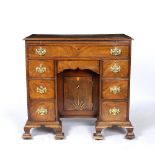 A GEORGE III AND LATER MAHOGANY KNEEHOLE DESK with brushing slide over one long drawer, six short