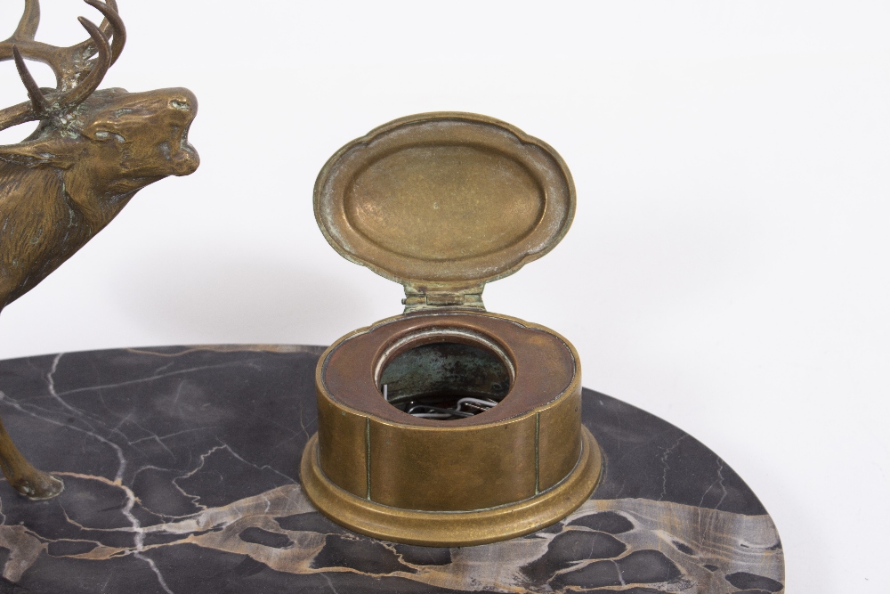 A LATE 19TH / EARLY 20TH CENTURY BRASS STAG AND INKWELL DESK STAND with an oval black marble base, - Image 3 of 5