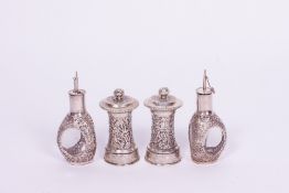 A PAIR OF EARLY 20TH CENTURY ORIENTAL WHITE METAL PEPPER GRINDERS with embossed floral decoration,