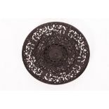 A CAST IRON PLATE with pierced decoration, decorated with hippocampi, tridents and scrolling