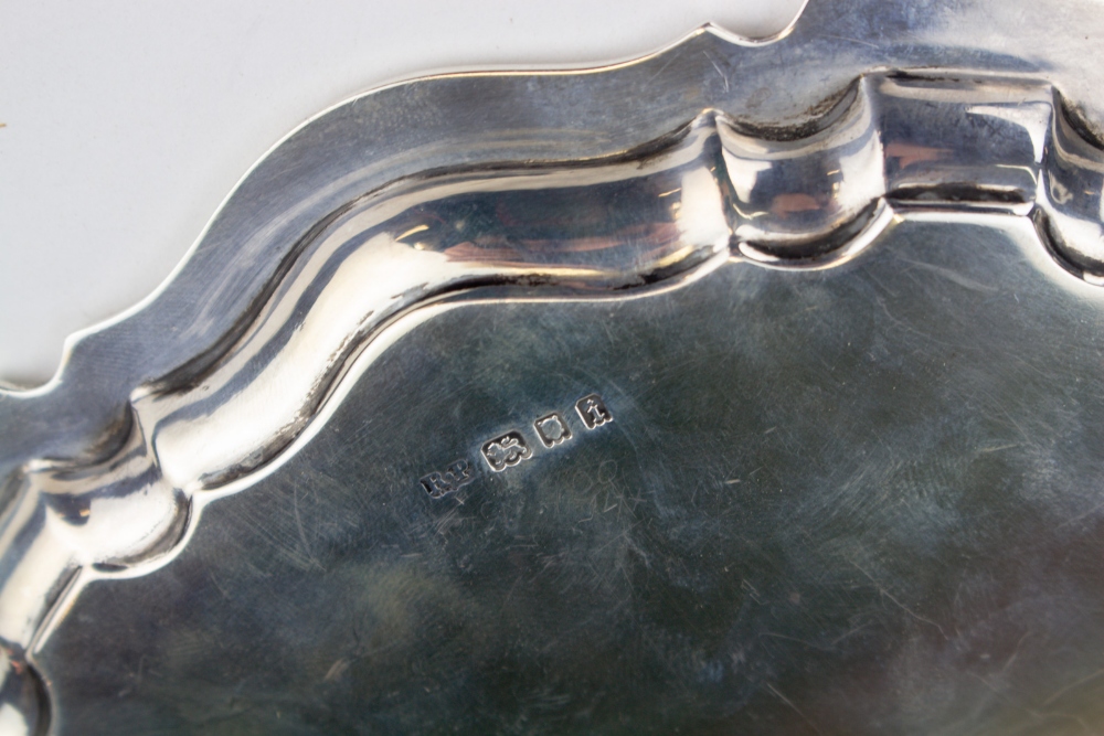 AN EARLY 20TH CENTURY SILVER CARD TRAY with a shaped edge and scroll feet, 20.5cm diameter, with - Image 5 of 5