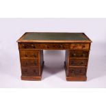 AN OAK PEDESTAL DESK with green leatherette inset top and turned knob handles, 122cm wide x 66cm