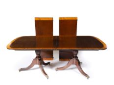 A GEORGIAN STYLE MAHOGANY AND SATINWOOD CROSS BANDED TWIN PEDESTAL DINING TABLE with two leaves,