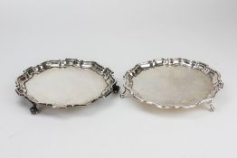 AN EARLY 20TH CENTURY SILVER CARD TRAY with a shaped edge and scroll feet, 20.5cm diameter, with