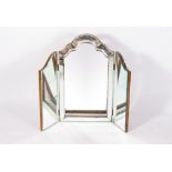 AN EARLY TO MID 20TH CENTURY THREE FOLD BEVELLED GLASS MIRROR with a shaped top and a walnut