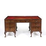 A MID TO LATE 20TH CENTURY VICTORIAN STYLE PEDESTAL DESK with a red leather inset top, nine
