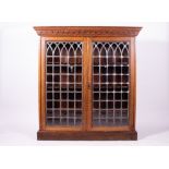 AN OAK FLOOR STANDING BOOKCASE the leaded glazed doors enclosing three adjustable shelves within,
